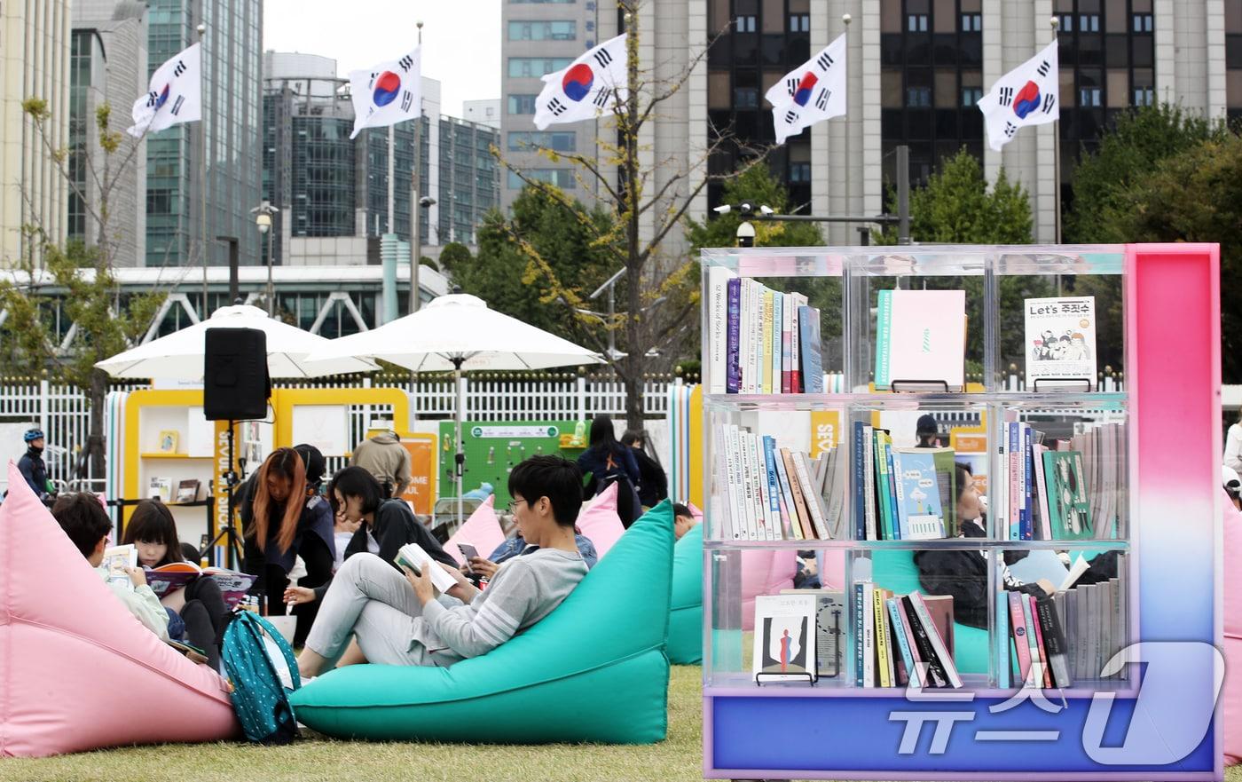 본문 이미지 - 13일 오후 휴일을 맞아 서울 종로구 광화문광장 '서울야외도서관 광화문책마당'을 찾은 시민들이 빈백 소파에 기대어 독서 삼매경에 빠져 있다.  2024.10.13/뉴스1 ⓒ News1 오대일 기자