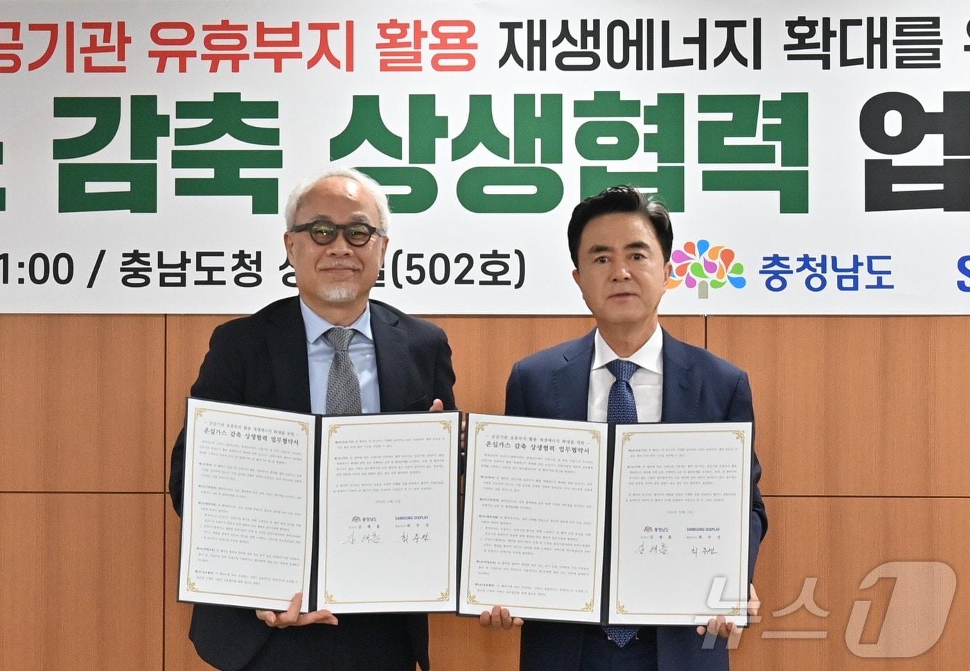 김태흠 충남지사(오른쪽)와 최주선 삼성디스플레이 대표이사가 14일 충남도청에서 ‘공공기관 유휴부지 활용 재생에너지 확대를 위한 온실가스 감축 상생협력 업무협약’을 체결한 뒤 기념촬영을 하고 있다. (충남도 제공) /뉴스1