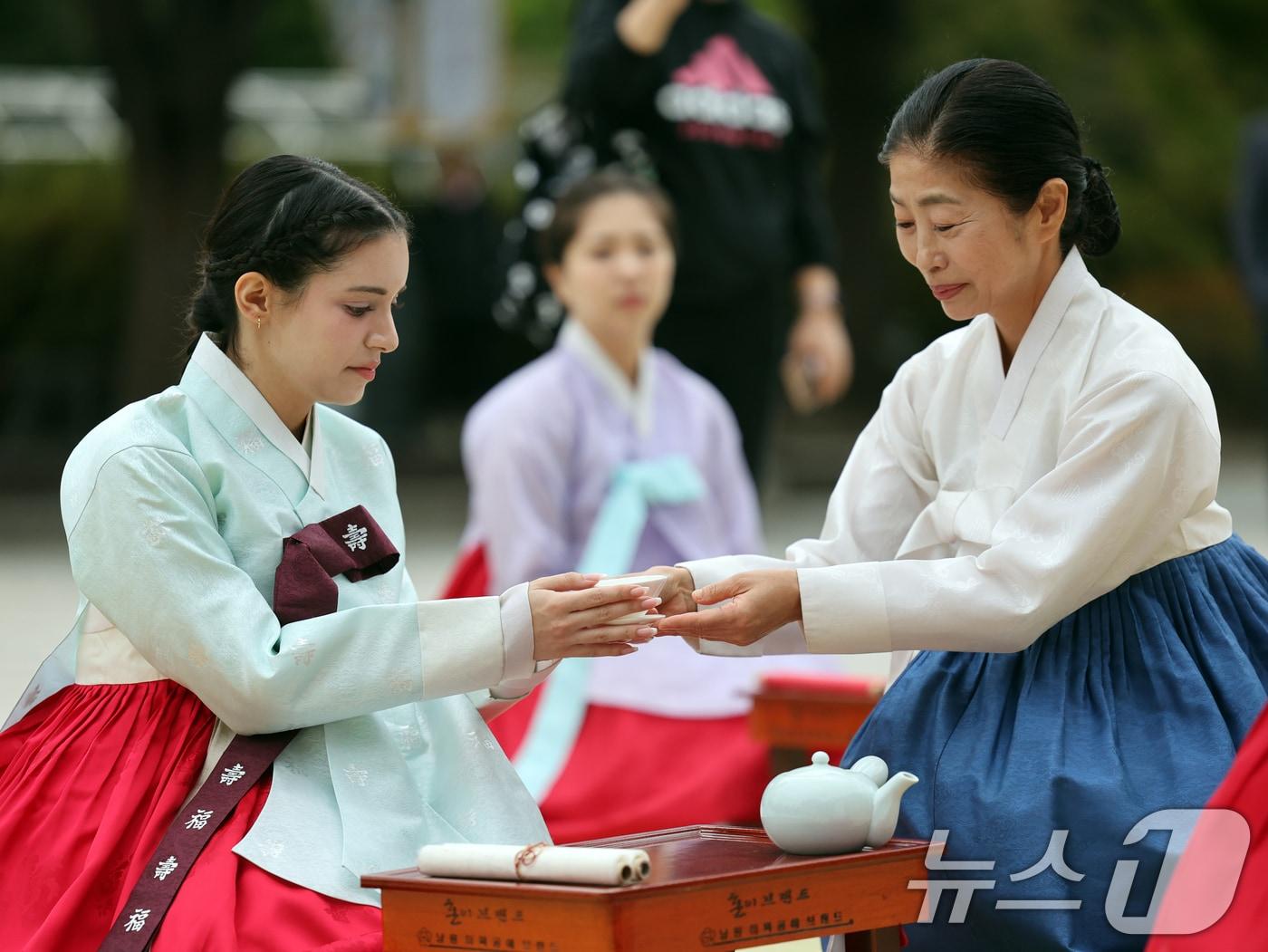 본문 이미지 - 14일 오후 서울 종로구 국립민속박물관에서 한복을 입은 시민과 외국인이 '2024 한복문화주간'을 맞아 전통 성년례 체험을 하고 있다. 2024.10.14/뉴스1 ⓒ News1 황기선 기자