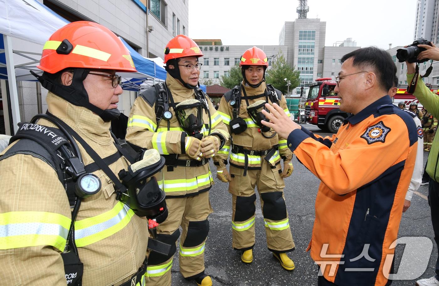 본문 이미지 - 강대훈 대전소방본부장(오른쪽)이 지난해 10월15일 대전 서부소방서를 찾은 대전시의회 행정자치위원회 위원들에게 전기차 화재 진압에 대해 설명하는 모습. (자료사진) 2024.10.15/뉴스1 ⓒ News1 김기태 기자