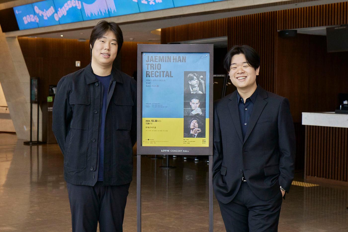 피아니스트 박재홍(왼쪽)과 첼리스트 한재민이 오는 30일 '트리오 연주회' 공연 포스터 앞에서 활짝 웃고 있다.(롯데문화재단 제공)