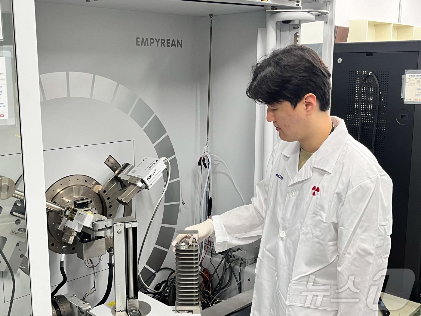 본문 이미지 - 한국원자력연구원 홍석재 연구원(제1 저자)이 고체전해질 표면 구조 분석을 위해 X-선 회절장치에 샘플을 로딩하고 있다. (원자력연 제공)/뉴스1