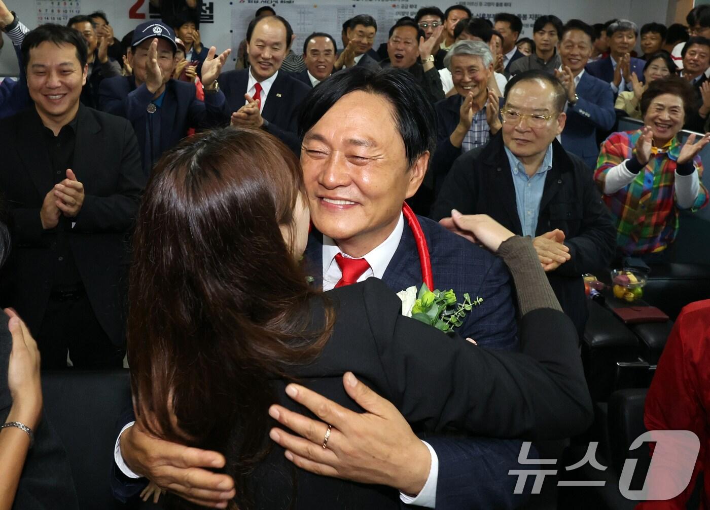 본문 이미지 - 박용철 국민의힘 10&bull;16 인천시 강화군수 보궐선거 후보가 16일 오후 강화군 강화읍 선거사무소에서 당선이 확실시 되자 딸의 축하를 받고 있다. 2024.10.16/뉴스1 ⓒ News1 김명섭 기자
