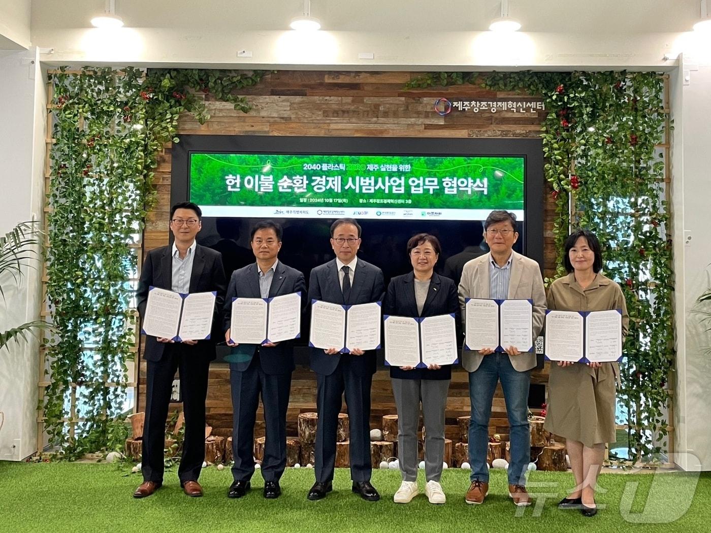 본문 이미지 - 제주도, 제주창조경제혁신센터, 한국환경공단제주지사, 제주시새활용센터, ㈜이브자리, ㈜제클린이 17일 '헌 이불 순환경제 시범사업' 업무협약 후 기념촬영하고 있다/뉴스1