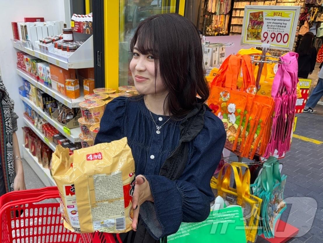 본문 이미지 - 농심과 코리아마트가 협업해 운영하는 &#39;K라면 슈퍼마켓&#39;에서 한 일본인 관광객이 &#39;신라면 툼바&#39;를 들고 있다.2024.10.17/ⓒ 뉴스1 이강 기자