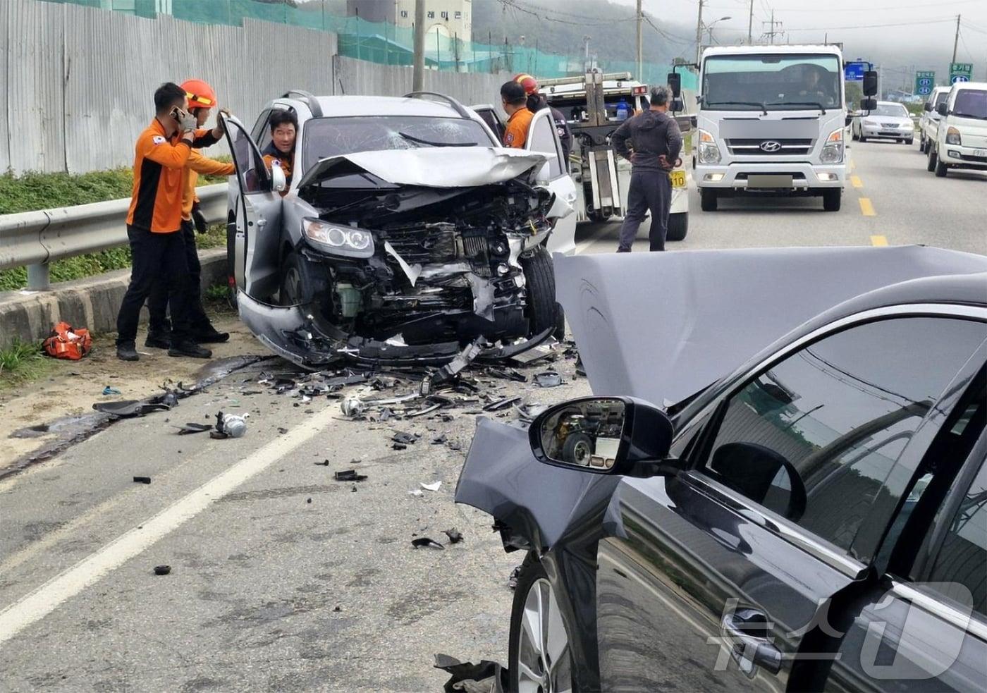 경북 영덕소방서 119대원들이 외부행사에 참가하기 위해 안동소방학교로 이동하는 과정에서 교통사고 현장을 목격하고 구조작업에 나서 차량에 갇혔던 4명을 구조한 후 사고 수습을 하고 있다. (영덕소방서제공) 2024.10.17/뉴스1  