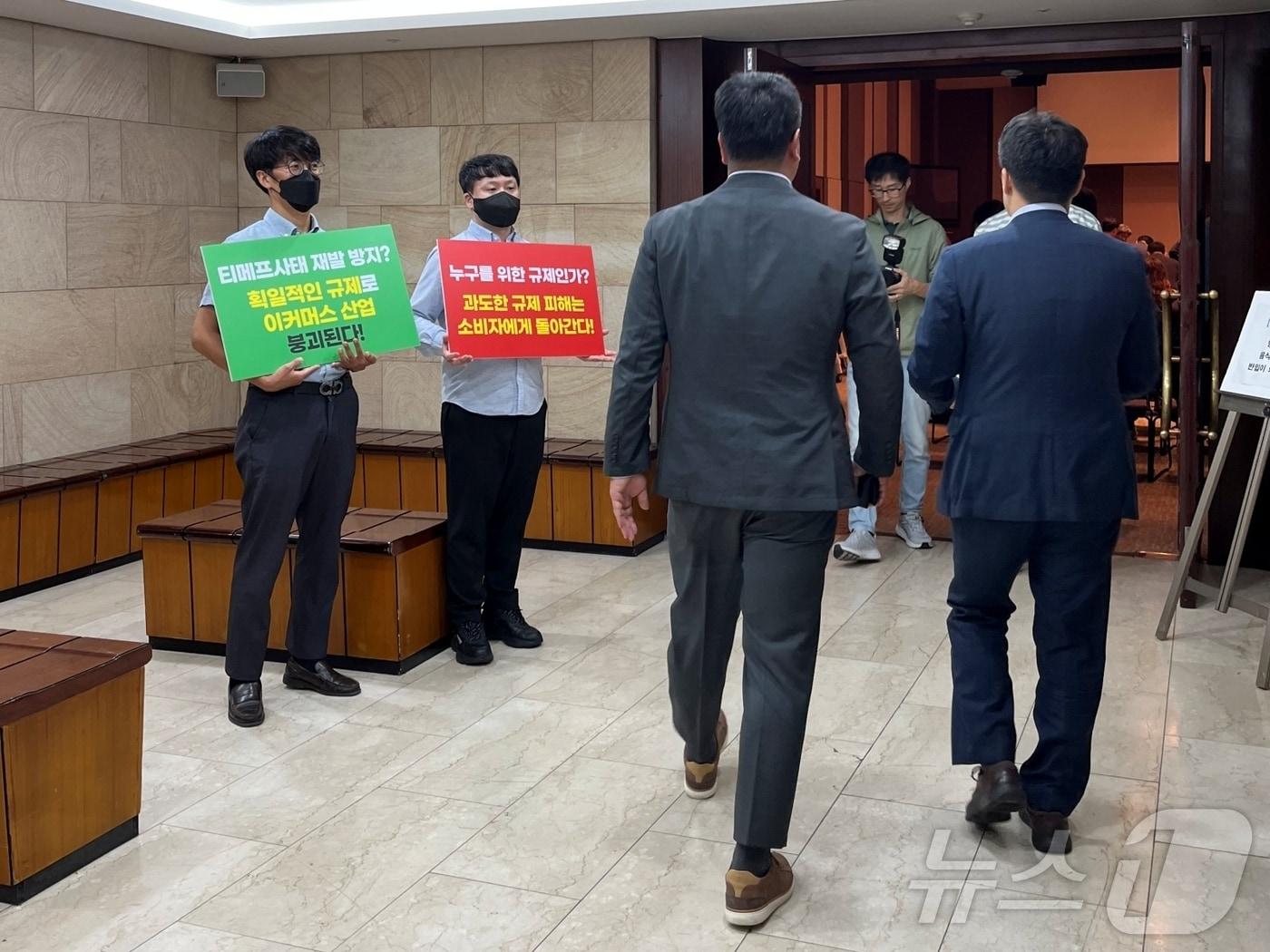 본문 이미지 - 지난 9월 열린 '티몬·위메프 재발 방지를 위한 대규모유통업법·전자금융거래법 개정안 공청회'에서 벤처기업협회 관계자들이 손팻말을 들고 있다.(벤처기업협회 제공)