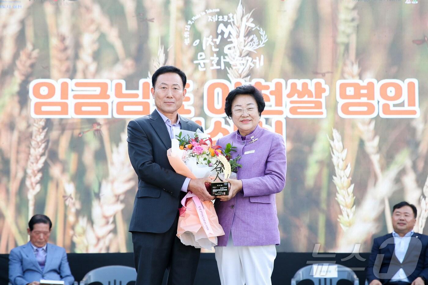 본문 이미지 - 지난 17일 이천시 농업테마공원에서 진행된 ‘제3회 임금님표 이천쌀 명인 선발대회’ 시상식에서 명인으로 선정된 최동석씨(왼쪽)가 김경희 이천시장과 기념촬영을 하고 있다.(이천시 제공)