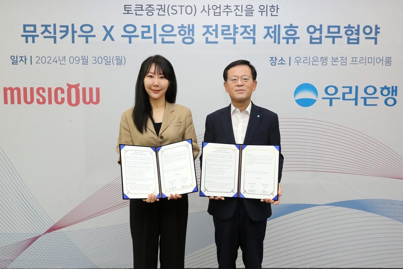 우리은행은 지난 30일 우리은행 본점에서 뮤직카우와 업무협약을 체결했다. 조병규 우리은행 은행장(오른쪽)이 뮤직카우 정현경 대표이사와 기념촬영을 하고 있다.