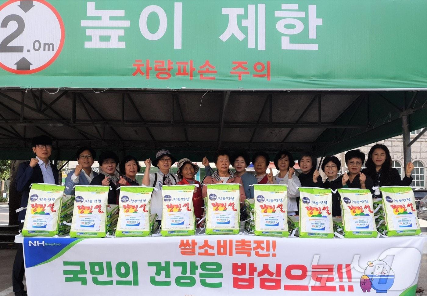 본문 이미지 - 탄동농협이 개최한 사랑의 쌀 나눔행사 참석자들이 기념 촬영을 하고 있다.(탄동농협 제공) 