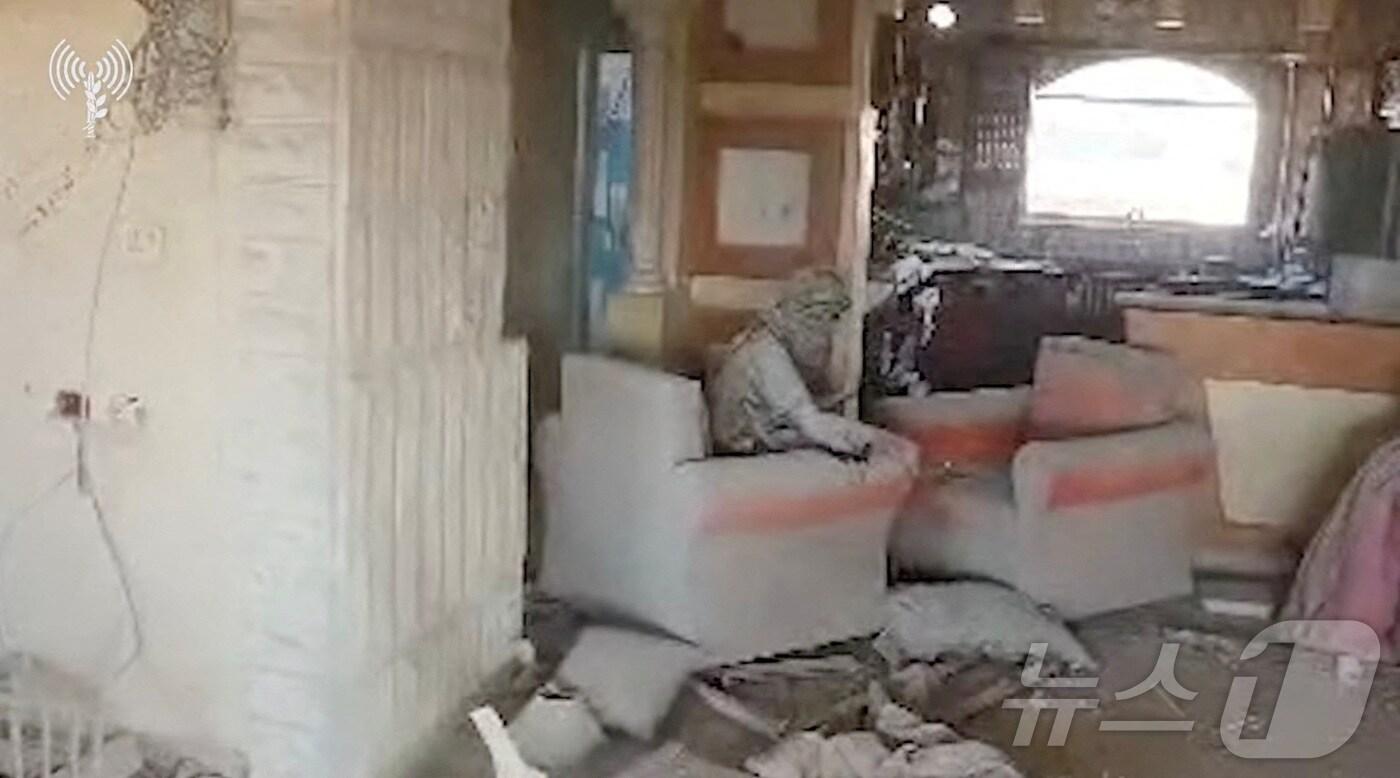 본문 이미지 - 17일(현지시간) 이스라엘군이 공개한 영상에서 팔레스타인 무장 정파 하마스의 수장 야히야 신와르로 추정되는 남성이 파괴된 건물 소파에 앉아 있다. 2024.10.17 ⓒ 로이터=뉴스1 ⓒ News1 정지윤 기자