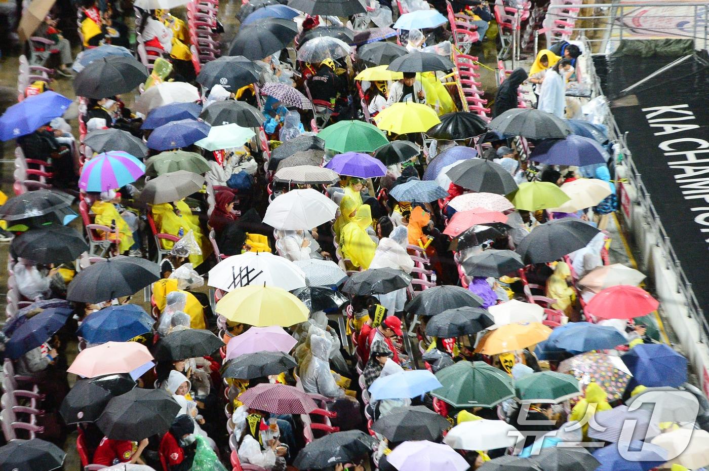 본문 이미지 - 광주기아챔피언스필드에서 야구팬들이 우산과 우비를 쓴 채 경기를 기다리고 있다. 2024.10.21/뉴스1 ⓒ News1 이승현 기자