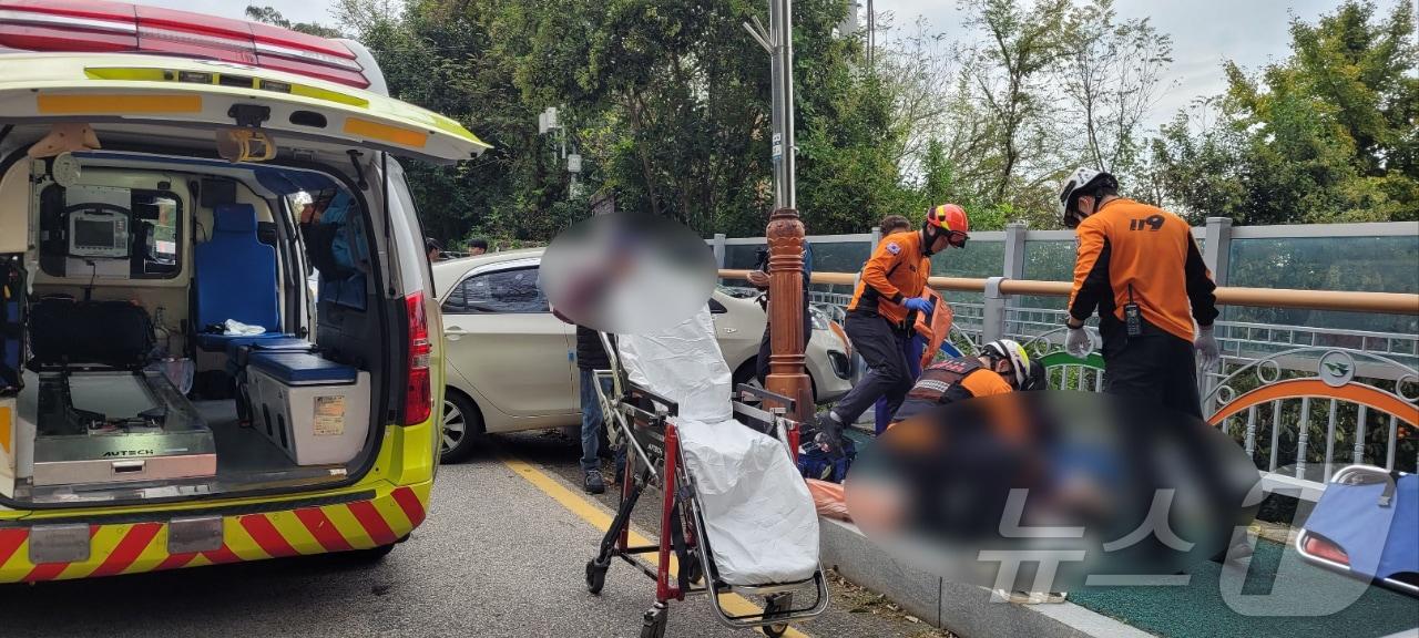 본문 이미지 - 21일 오후 2시 45분쯤 전남 목포시 죽교동 한 도로에서 A 씨(86)가 몰던 모닝이 인도를 덮쳐 보행자 3명이 다쳤다. 사진은 구급대원들이 부상자들에게 응급처치를 하고 있는 모습. (목포소방 제공) 2024.10.22/뉴스1 