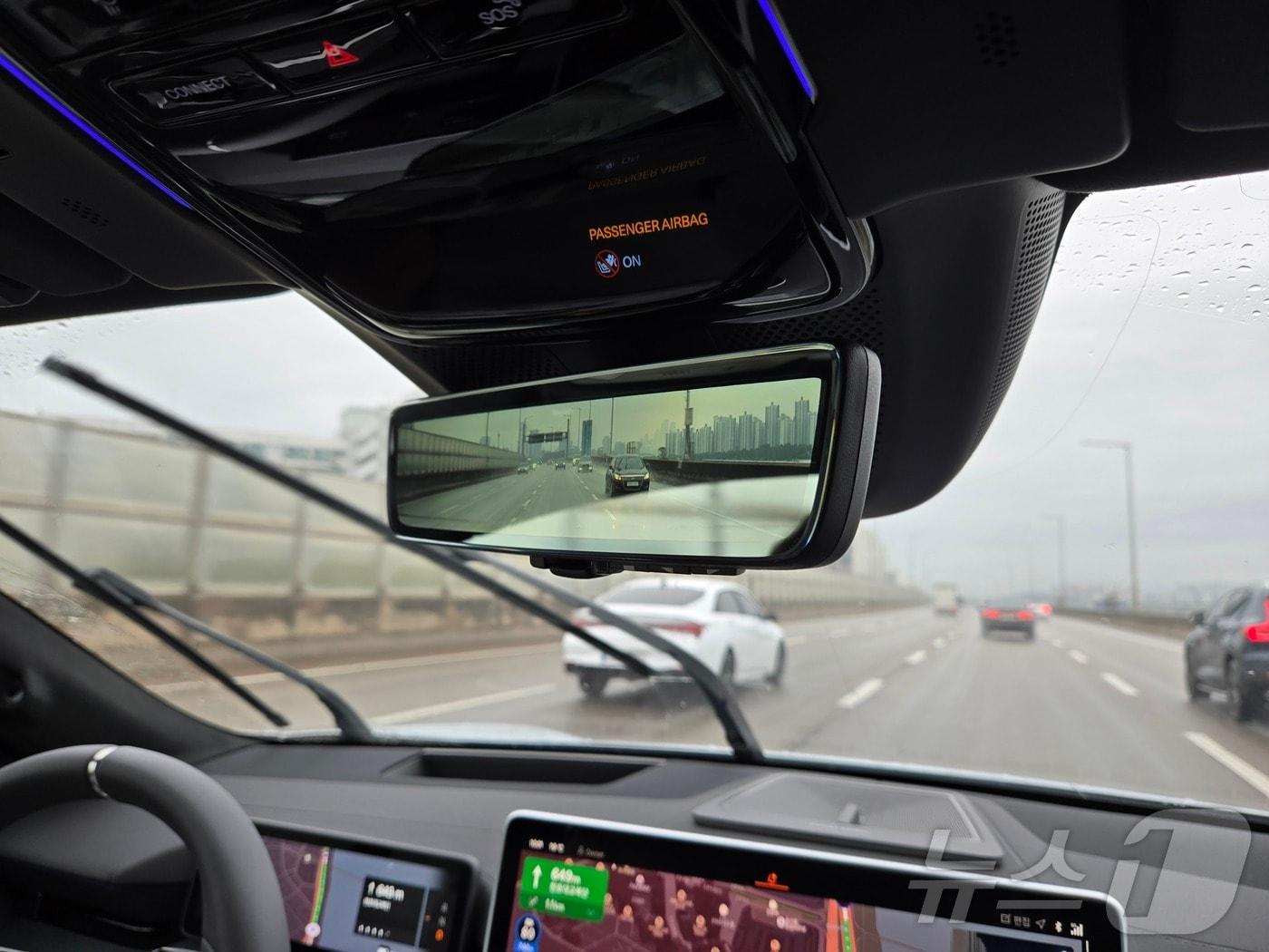 본문 이미지 - 22일 서울 강변북로를 달리는 폴스타4 디지털 룸미러에 후방 상황이 표시된 모습. 양방향 리어뷰 HD카메라가 뒷유리를 대신해 실시간으로 후방 상황을 디지털 룸미러로 송출했다. 빗길 주행 중인데도 디지털 룸미러는 빗물 한방울 없이 깨끗했다. 2024.10.22.