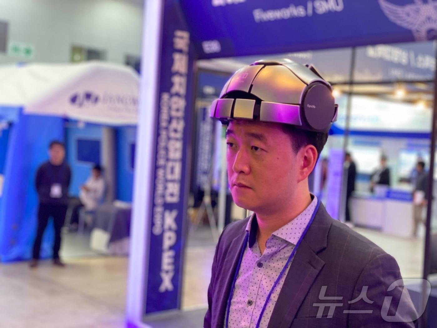 본문 이미지 - 23일 송도컨벤시아에서 열린 '제6회 국제치안산업대전'에서 한 관람객이 마약 중독 치료 등에 활용할 수 있는 의료기기를 시연하고 있다. 경찰청과 인천광역시가 공동 주최하는 이번 행사는 26일까지 4일간 진행된다. 2024.10.23/뉴스1 ⓒ News1 이기범 기자