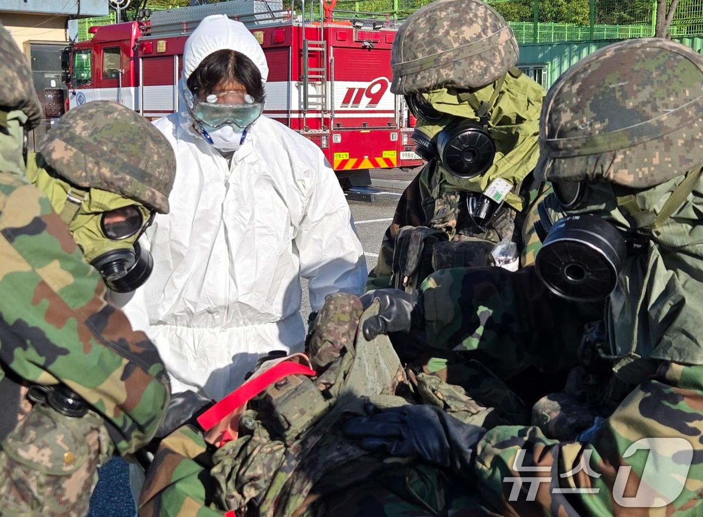 본문 이미지 - 육군 50사단 해룡여단이 23일 경북 영덕군 생활체육공원에서 실시된 대량사상자 관리 훈련에서 화학탄에 오염된 장병을 확인하고 있다. (육군 50사단제공) 2024.10.23/뉴스1 ⓒ News1 최창호 기자