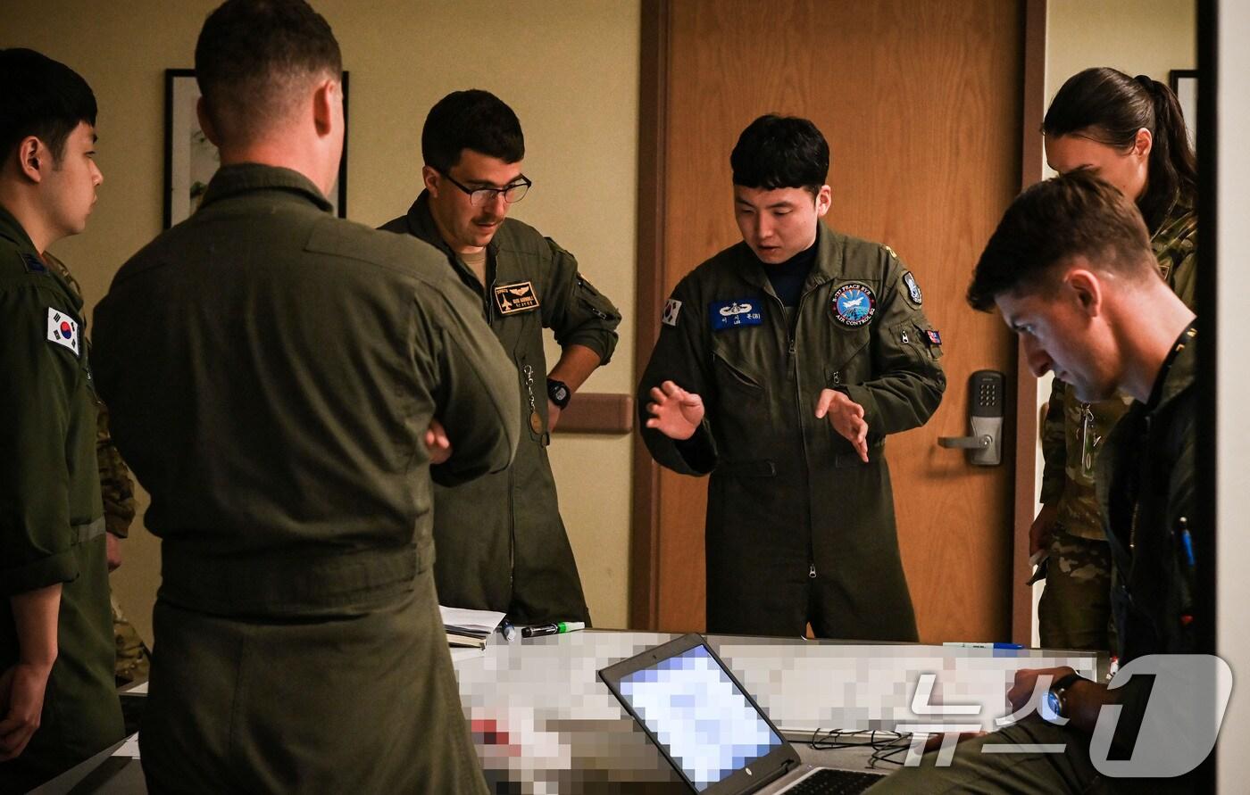 공군은 미 공군과 함께 지난 21일부터 오는 11월 1일까지 대규모 연합공중훈련인 ‘프리덤 플래그(Freedom Flag)’ 훈련을 실시하고 있다고 24일 밝혔다. 지난 23일 오산기지에서 훈련에 참가한 한미 조종사들이 전술토의하고 있다. (공군 제공) 2024.10.24/뉴스1