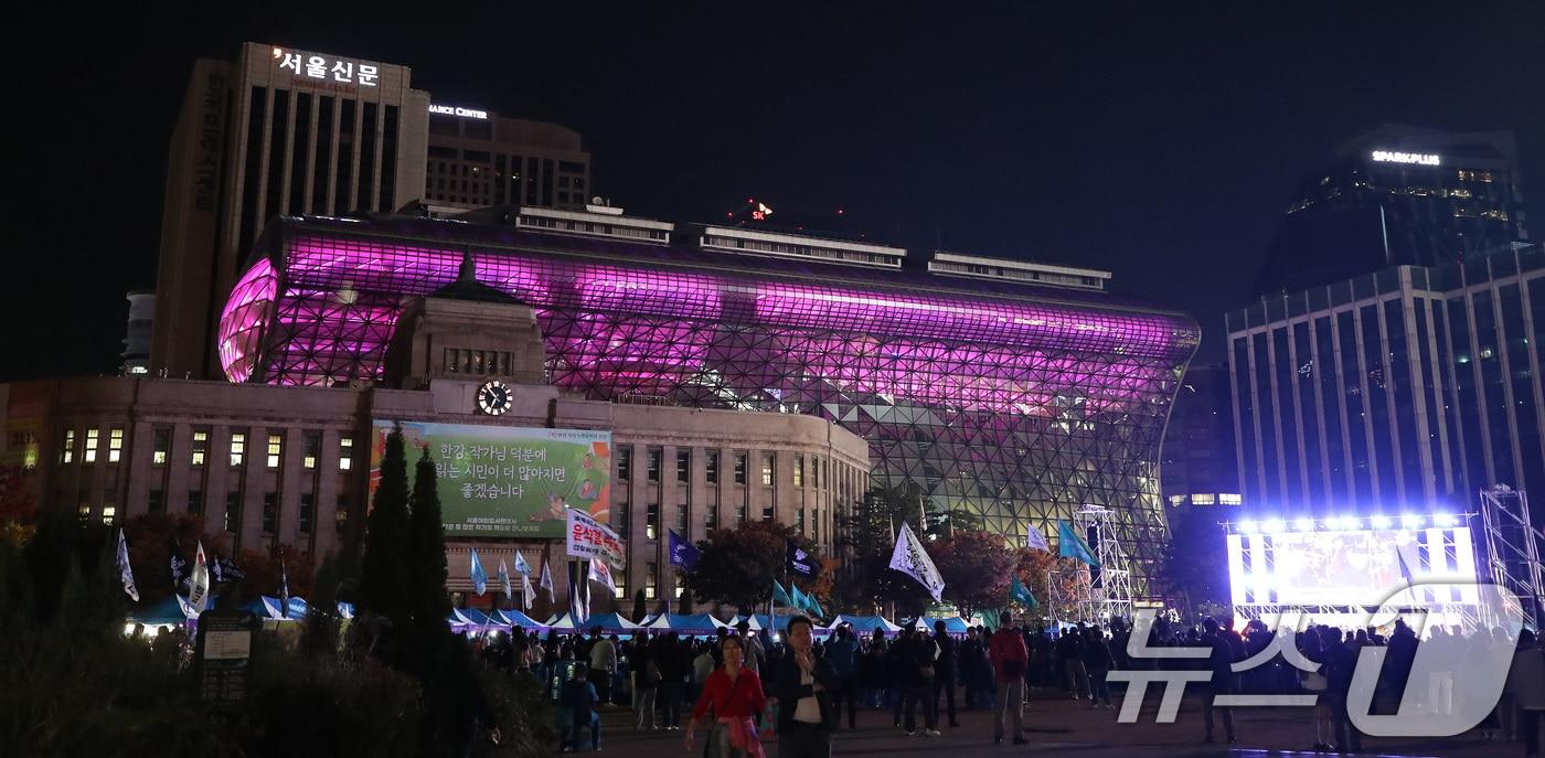 26일 오후 서울 중구 서울광장에서 열린 10.29 이태원참사 2주기 시민추모대회 뒤로 서울시청이 이태원참사를 추모하는 보랏빛으로 물들어 있다. 2024.10.26/뉴스1 ⓒ News1 임세영 기자