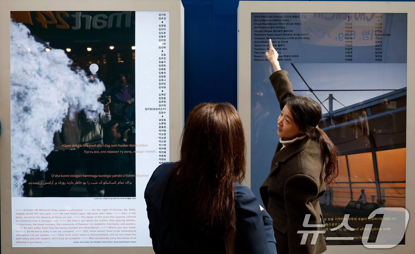 권은비 작가가 28일 서울 용산구 이태원 참사 골목 '10.29 기억과 안전의길'에서 열린 새로운 10·29 이태원 참사 기억과 안전의 길 빌보드 개막식에서 희생자 그레이스 라쉐드의 어머니 조안 라쉐드에게 작품 소개를 하고 있다. (공동취재) 2024.10.28/뉴스1 ⓒ News1 박세연 기자