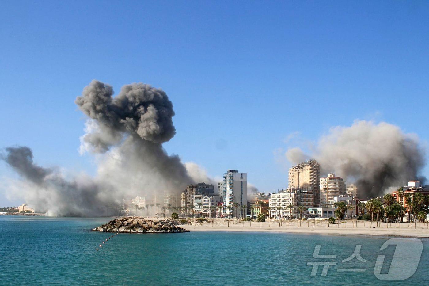 본문 이미지 - 28일(현지시간) 레바논 남부 티레에서 이스라엘 군의 공습을 받아 연기 기둥이 솟아 오르고 있다. 2024.10.29 ⓒ AFP=뉴스1 ⓒ News1 우동명 기자