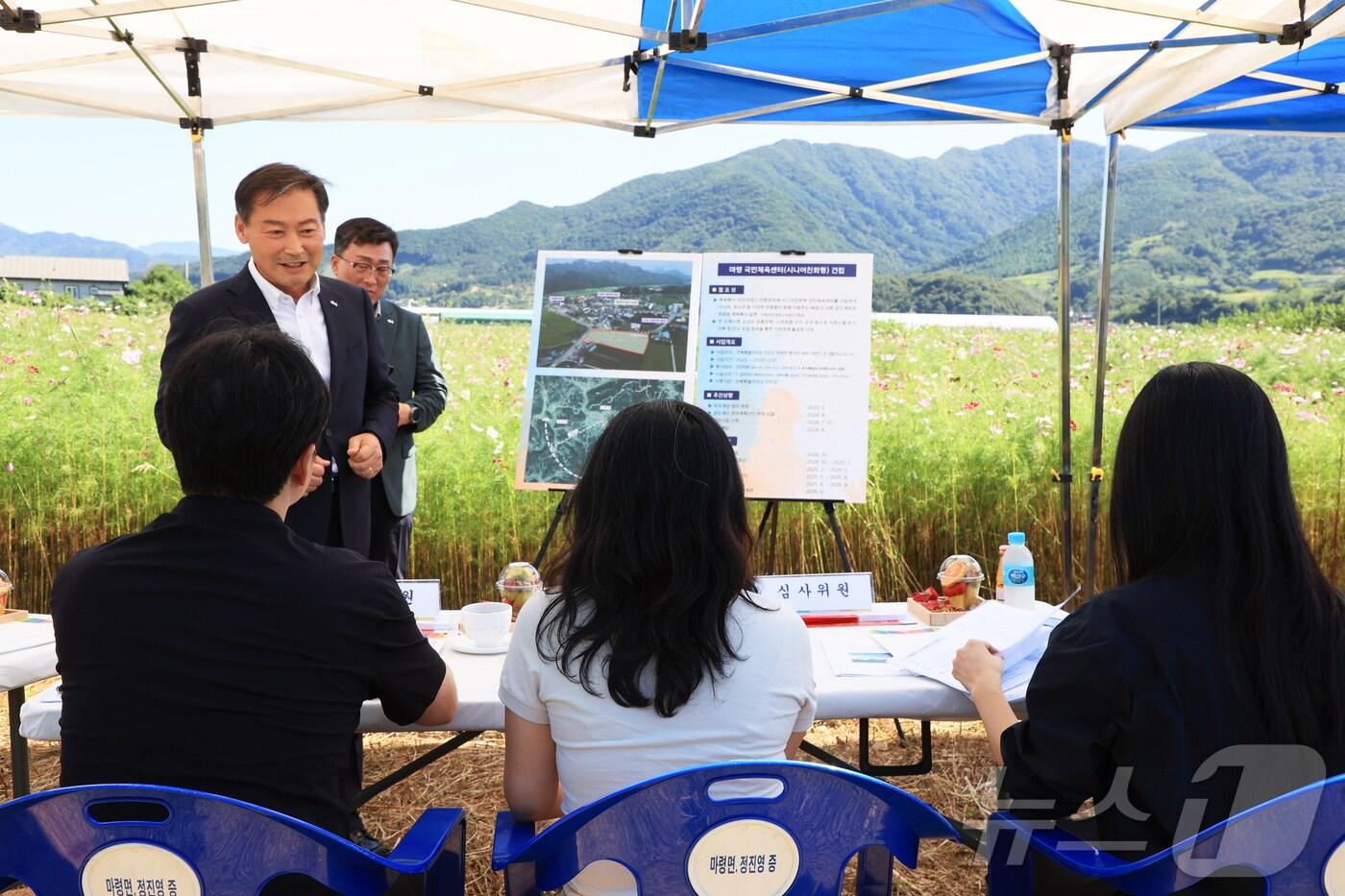 본문 이미지 - 전춘성 전북자치도 진안군수가 시니어 친화형 국민체육센터가 들어설 마령면 현지에서 문체부 담당자들에게 설명을 하고 있다.(진안군제공)2024.10.3/뉴스1
