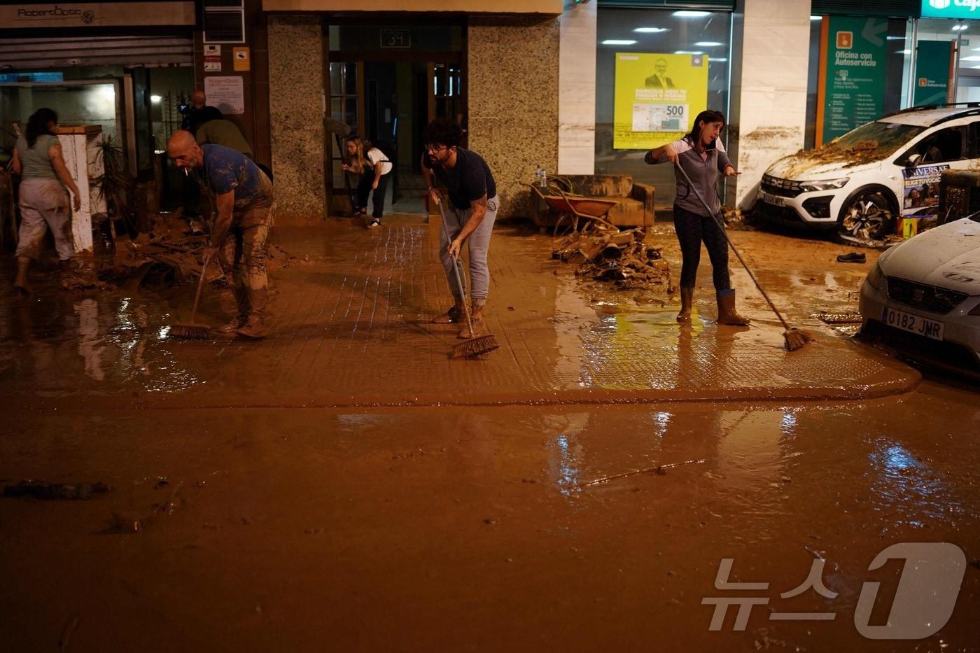본문 이미지 - 30일(현지시간) 스페인 동부 발렌시아주 남부의 데라토레 지역에서 주민들이 홍수로 인해 진흙 범벅이 된 거리를 청소하고 있다. 2024.10.30 ⓒ AFP=뉴스1 ⓒ News1 김지완 기자