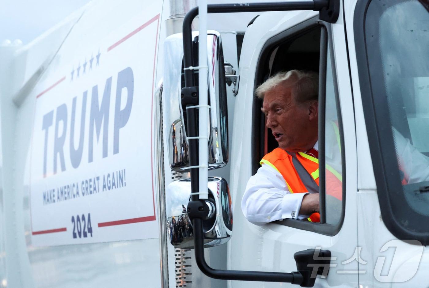 본문 이미지 - 30일(현지시간) 미국 공화당 대선후보 도널드 트럼프 전 대통령이 위스콘신주 그린베이에서 그의 이름과 선거 구호인 '미국을 다시 위대하게'가 적힌 쓰레기 트럭 운전석에 앉아 있다. 2024.10.30 ⓒ 로이터=뉴스1 ⓒ News1 김지완 기자