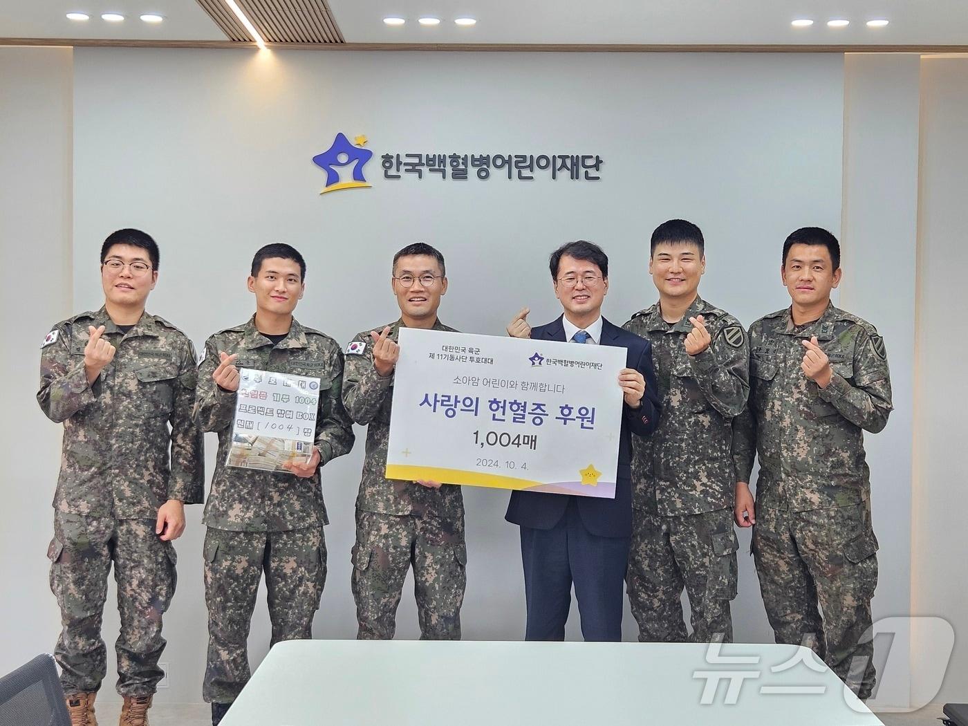 본문 이미지 - 11기동사단 투호대대 장병들이 4일 한국 백혈병 어린이 재단을 방문해 직접 모은 헌혈증 1004장을 기부한 뒤 기념촬영을 하고 있다.(11사단 제공)