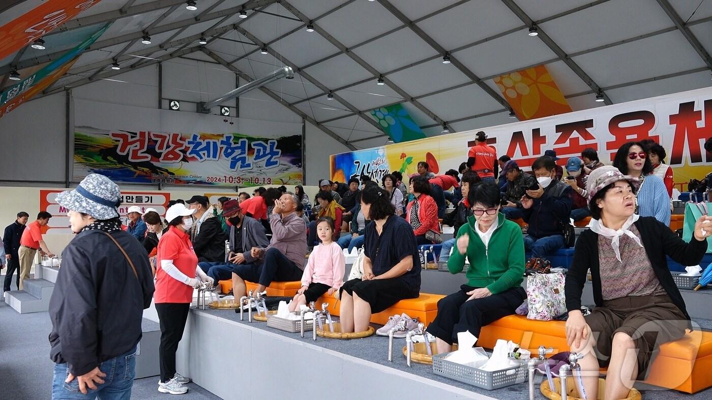 금산세계인삼축제장을 찾은 관람객들이 홍삼족욕을 즐기고 있다.(금산군 제공)/ 뉴스1