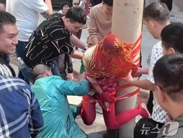 본문 이미지 - 테이프에 칭칭 감겨 전봇대에 매달린 신부 - 웨이보 갈무리