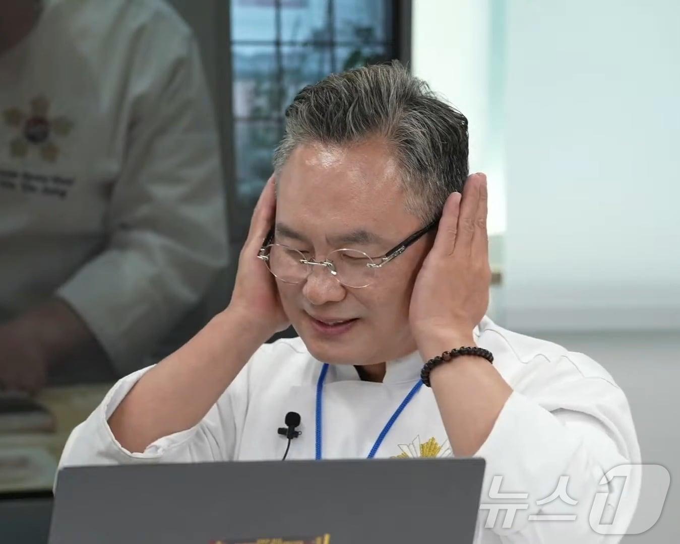 본문 이미지 - 안유성 가매일식 대표가 자신의 유튜브채널에서 흑백요리사 후일담을 전하며 가장 잘 맞았던 참가자로 김도윤 쉐프를 언급하며 김 쉐프의 트레이트마크인 귀마개를 표현하고 있다.(유튜브 백수저 안유성)2024.10.6./뉴스1