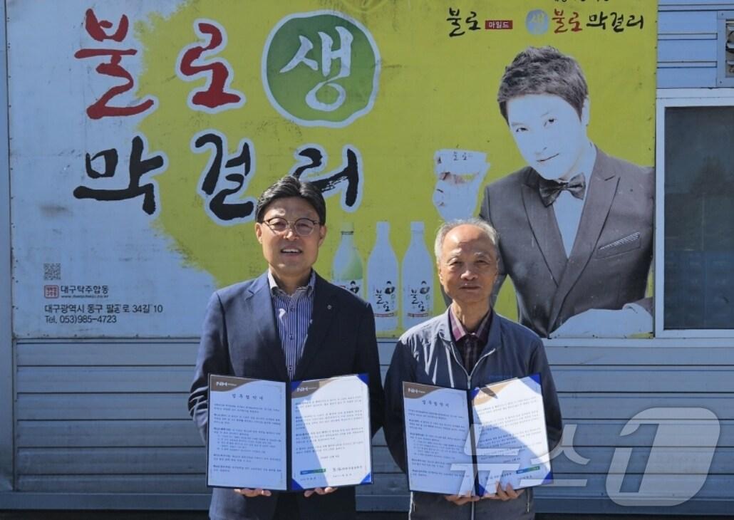 본문 이미지 - 이청훈 대구농협 본부장(왼쪽)과 최종국 대구불로탁주 대표가 우리 쌀 소비촉진을 위한 협약을 체결한 뒤 협약서를 펼쳐 보이고 있다.(대구농협 제공)