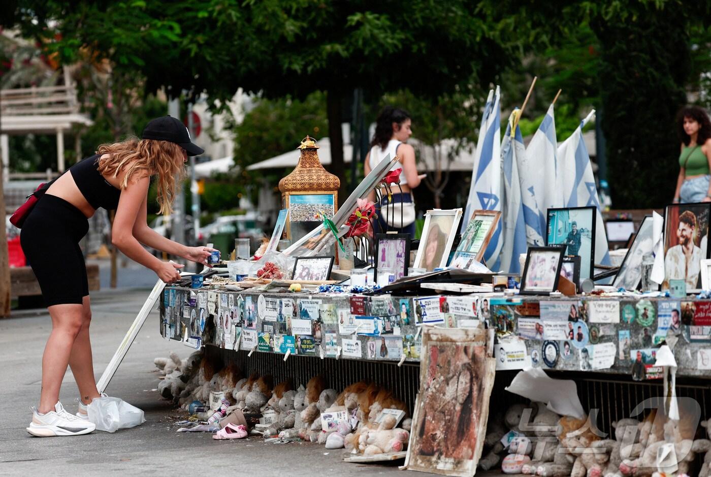 팔레스타인 무장정파 하마스의 이스라엘 기습공격 1주기를 맞은 7일(현지시간) 한 여성이 텔아비브에서 하마스에 의해 납치된 인질들의 사진을 보고 있다. 2024.10.07 ⓒ 로이터=뉴스1 ⓒ News1 최종일 기자