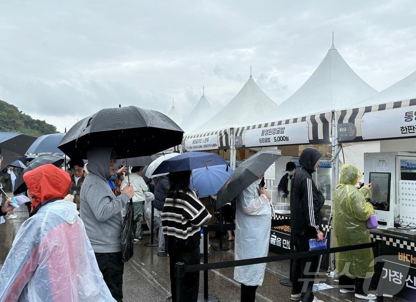 본문 이미지 - 1일 통영어부장터 축제를 방문한 시민들이 우산을 쓴 채 줄을 서있다.2024.11.01/뉴스1 강미영기자