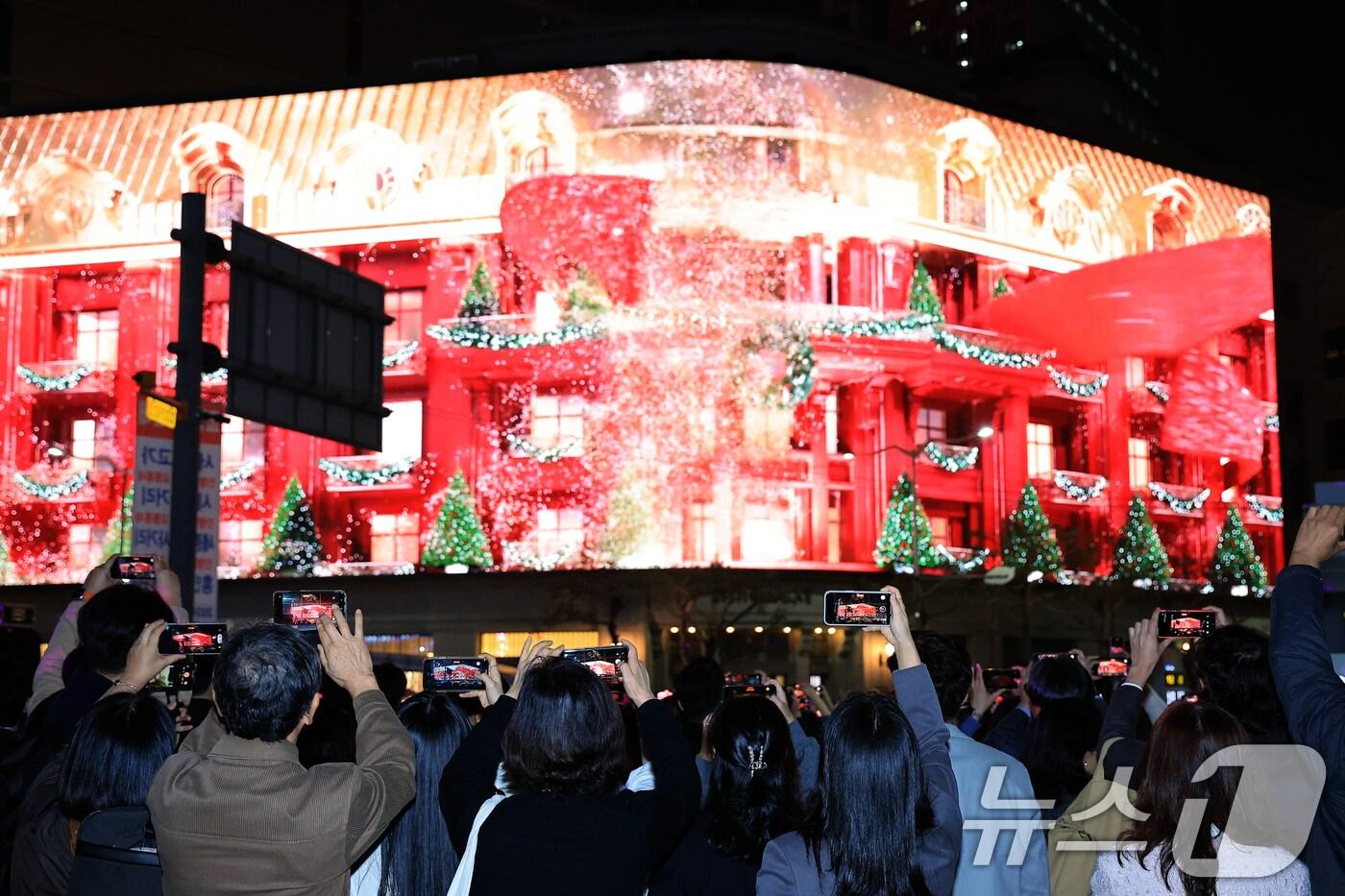 1일 오후 서울 중구 신세계백화점 본점 앞을 찾은 시민들이 외벽에 설치된 LED 사이니지 '신세계스퀘어'에서 펼쳐진 미디어 파사드를 휴대전화로 촬영하고 있다. 2024.11.1/뉴스1 ⓒ News1 박정호 기자