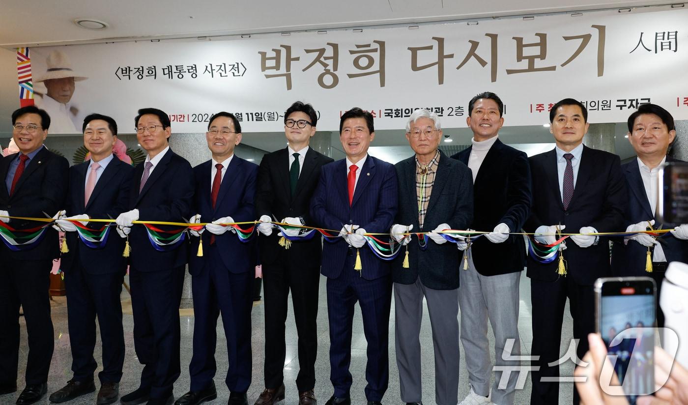본문 이미지 - 한동훈 국민의힘 대표가 11일 서울 여의도 국회의원회관에서 열린 박정희 대통령 사진전 '박정희 다시보기'에서 테이프 커팅을 하고 있다. 왼쪽부터 송언석, 김기현, 김상훈, 주호영 의원, 한 대표, 구자근 의원, 김세권 작가, 김장호 구미시장, 박대출, 권영진 의원. 2024.11.11/뉴스1 ⓒ News1 안은나 기자