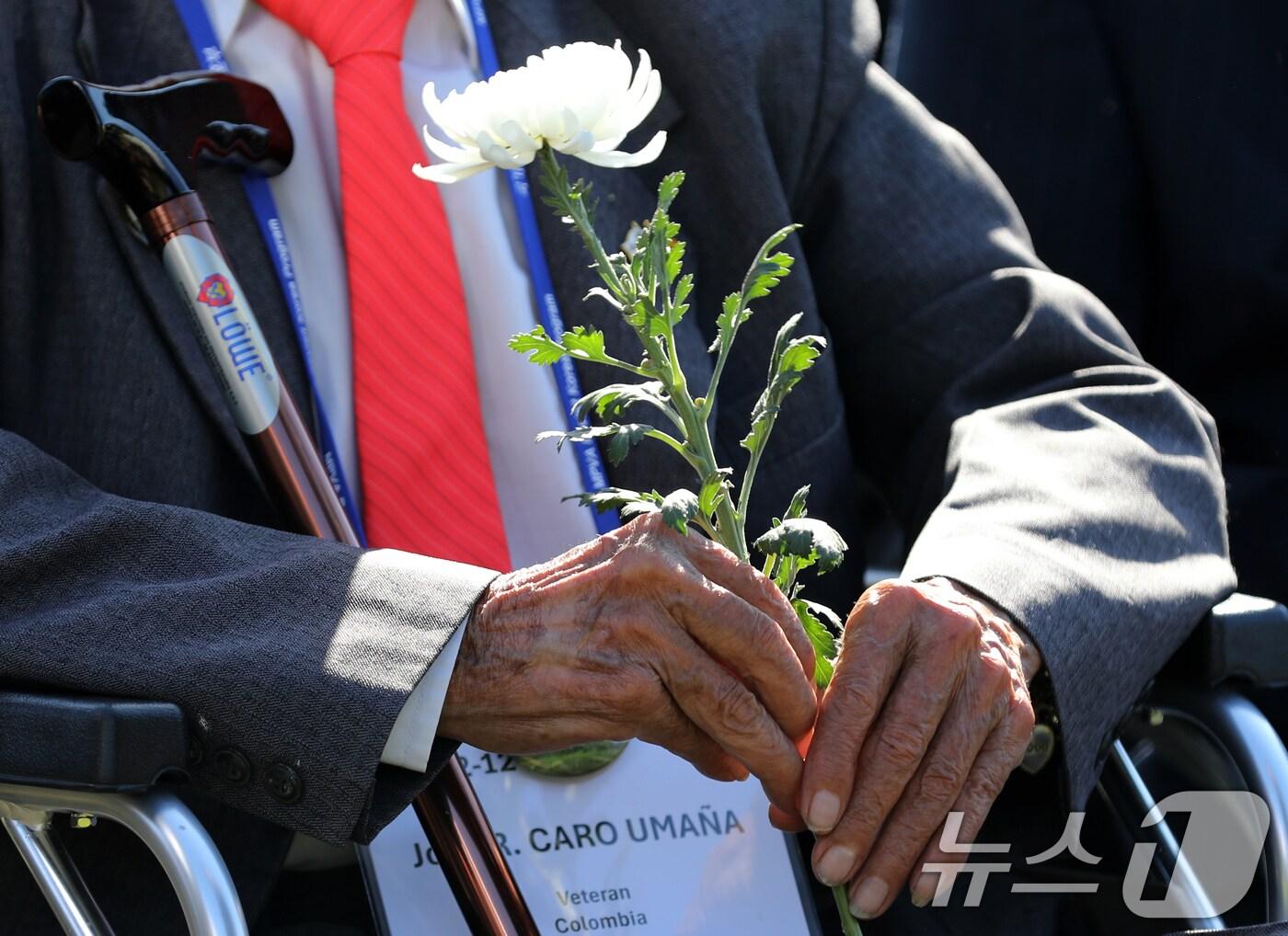 본문 이미지 - 11일 부산 남구 유엔기념공원에서 열린 턴 투워드 부산 유엔참전용사 국제추모의 날 기념식에서 6·25전쟁 유엔군 참전용사가 국화꽃을 들고 있다. 2024.11.11/뉴스1 ⓒ News1 윤일지 기자