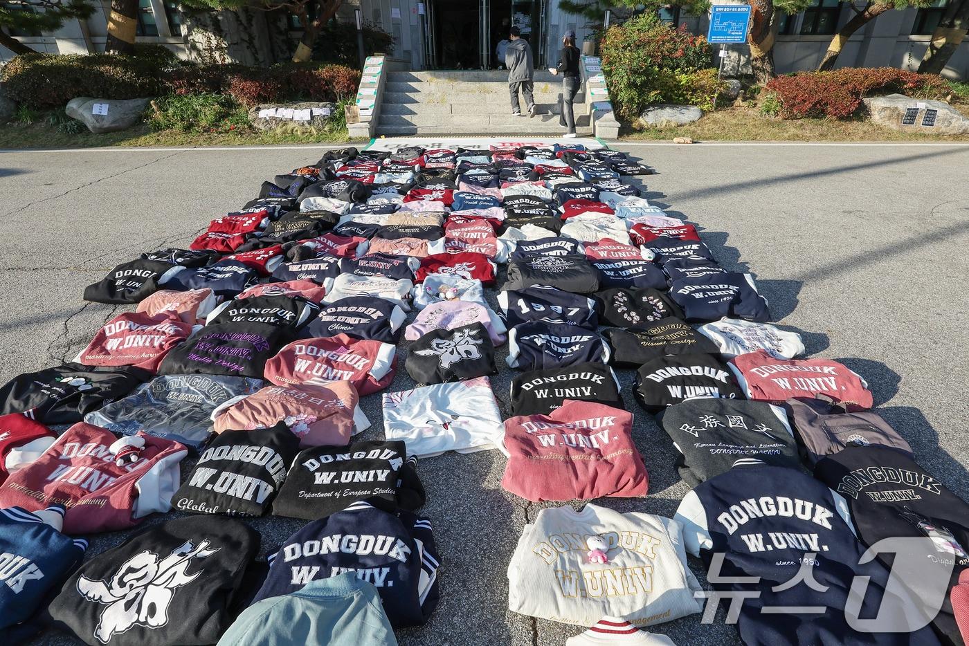 본문 이미지 - 11일 오후 서울 성북구 동덕여자대학교에서 학교 측의 남녀공학 전환 추진에 반발하는 학생들이 항의의 의미로 벗어 놓은 학교 점퍼가 본관 앞을 가득 메우고 있다. 2024.11.11/뉴스1 ⓒ News1 민경석 기자