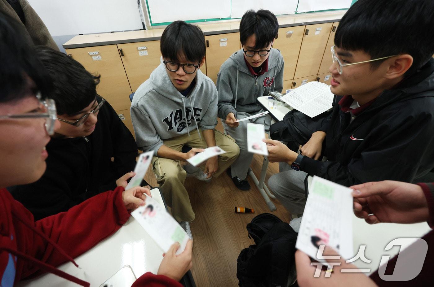 본문 이미지 - 2025학년도 대학수학능력시험 예비소집일인 13일 서울 종로구 중앙고등학교에서 3학년 학생들이 교사로부터 수험표를 배부받은 뒤 확인하고 있다. (공동취재) 2024.11.13/뉴스1 ⓒ News1 임세영 기자