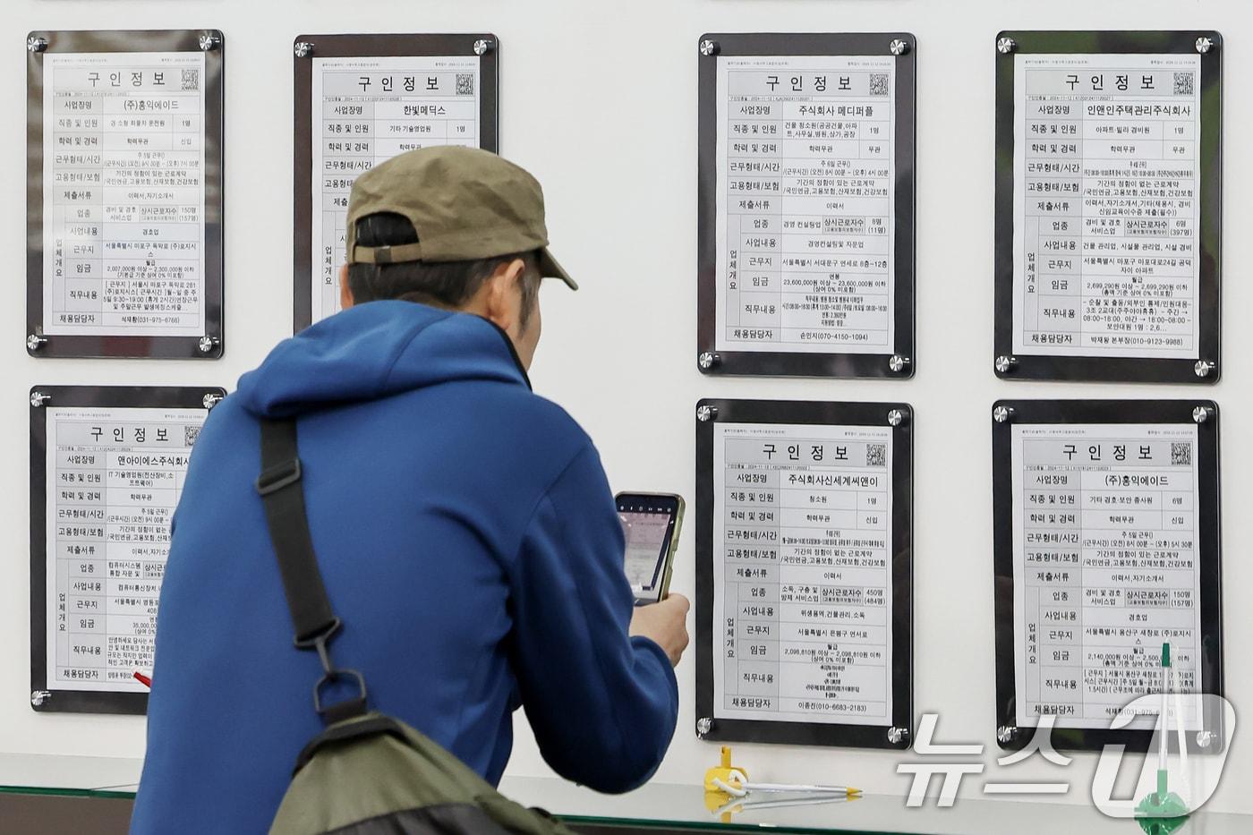 본문 이미지 - 서울 마포구 서부고용복지플러스센터에서 한 구직자가 일자리 정보 게시판 속 구인업체 정보를 휴대전화 카메라에 담고 있다. 2024.11.13/뉴스1 ⓒ News1 민경석 기자