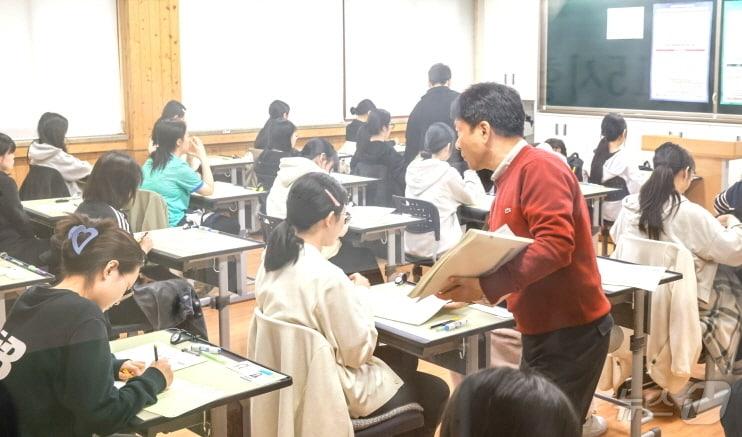 본문 이미지 - 전북 전주시의 한 수험장 시험실에서 학생들이 시험지를 배부받고 있다.(전북교육청 제공)/뉴스1