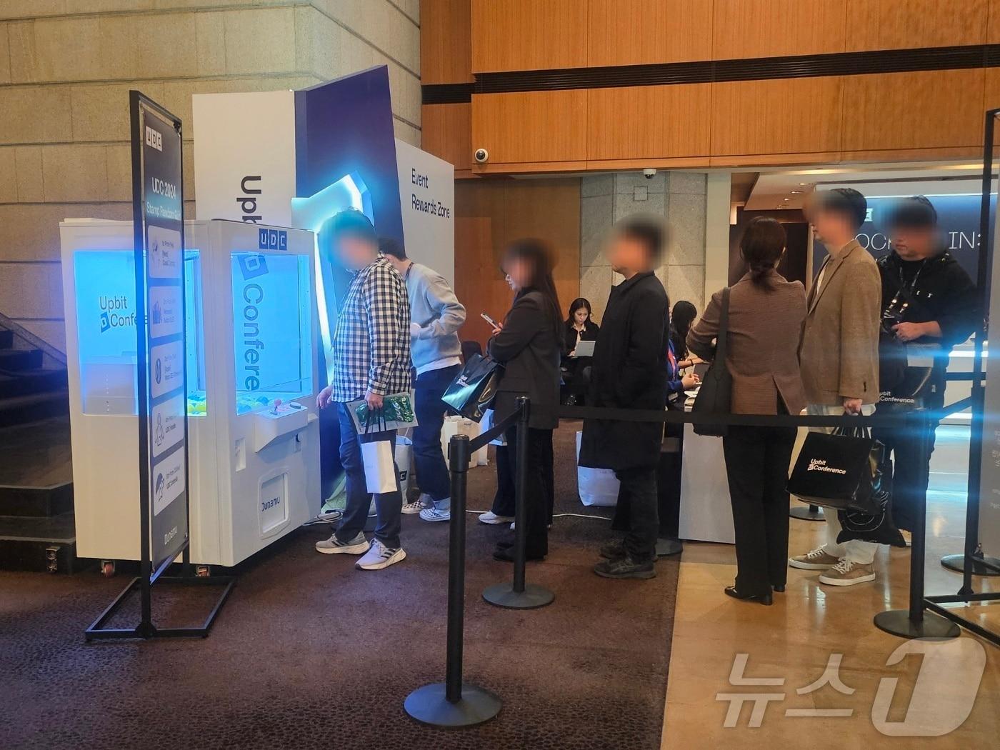 본문 이미지 - 14일 서울 신라호텔에서 열린 '업비트D콘퍼런스(UDC 2024)' 현장에서 참가자들이 선물 뽑기 이벤트에 참여하기 위해 줄을 서고 있다.