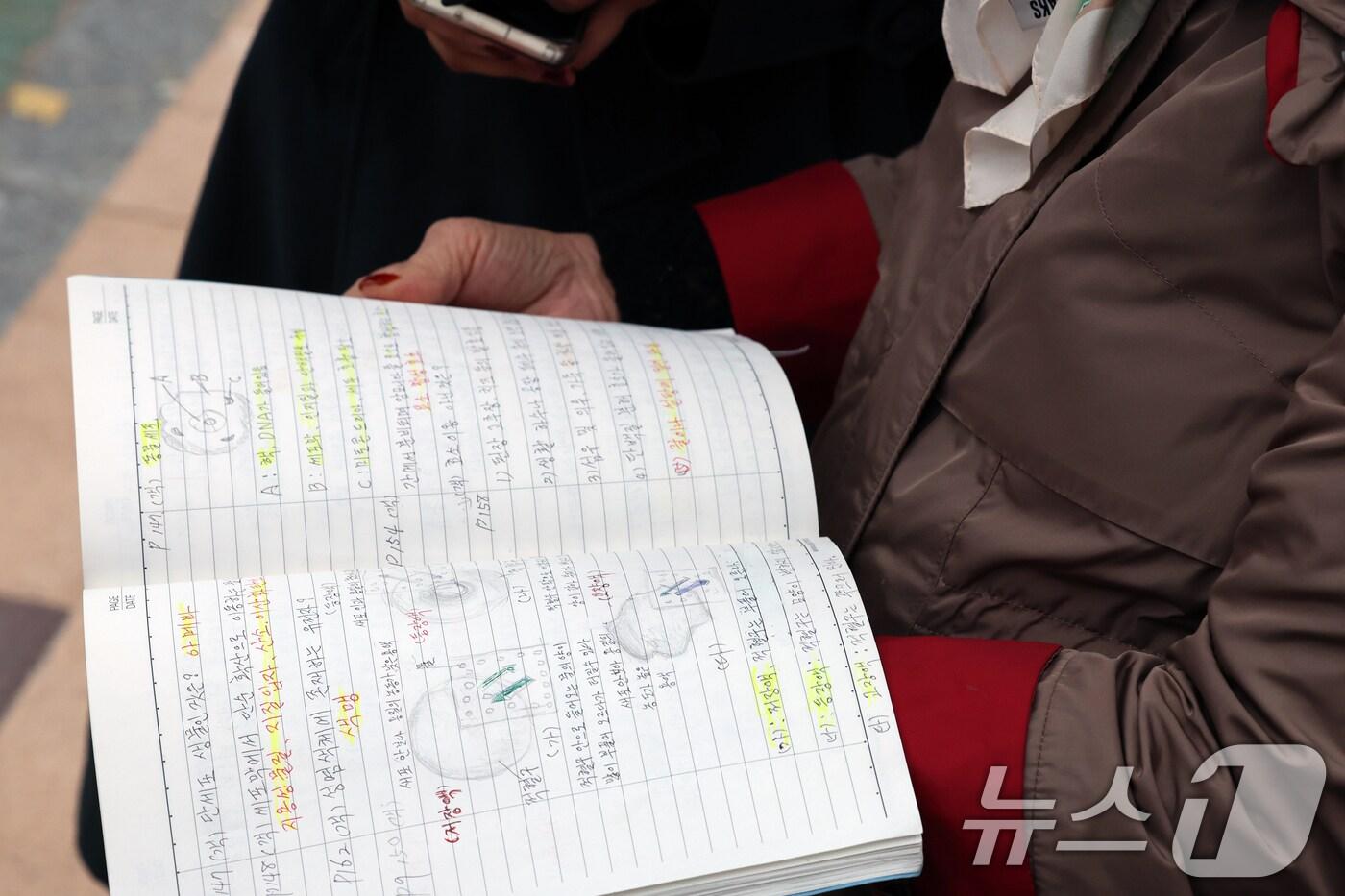 본문 이미지 - 2025학년도 대학수학능력시험일인 14일 오후 서울시교육청 12지구 제22시험장인 서울 마포구 홍익대학교사범대학부속여자고등학교에서 일성여자중고등학교 최고령 수험생 임태수(83) 할머니가 시험장을 나선 후 취재진에게 필기노트를 보이고 있다. 2024.11.14/뉴스1 ⓒ News1 황기선 기자