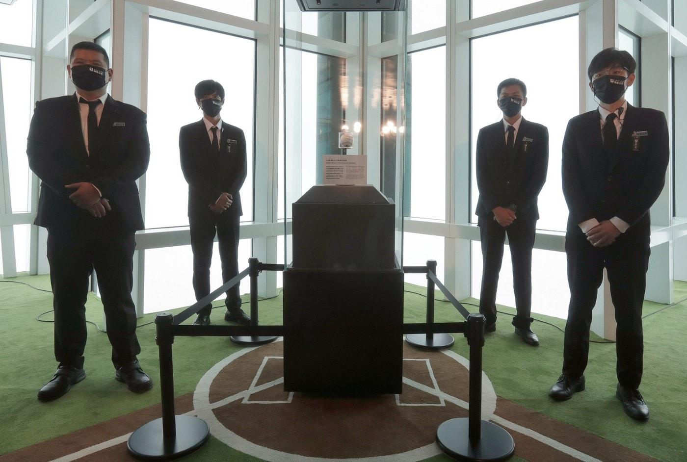 본문 이미지 - 오타니 쇼헤이의 50호 홈런공이 대만 타이베이 101빌딩에서 공개됐다. 사진은 홈런공을 지키는 경호원들. (MLB SNS 캡처)