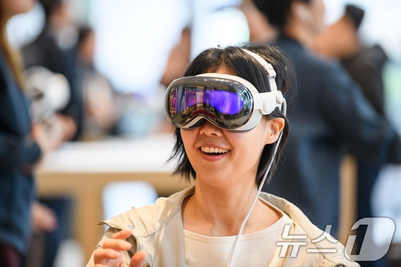 본문 이미지 - 15일 서울 중구 애플 명동점에서 한 고객이 국내 출시된 '애플 비전 프로(Apple Vision Pro)'를 체험하고 있다. 애플이 '공간형 컴퓨터'라 부르는 비전 프로는 안경처럼 착용하는 기기다. 180도 시야각을 갖춘 전면 디스플레이로 가상현실(VR)과 증강현실(AR) 콘텐츠와 서비스를 이용할 수 있다. (애플 제공) 2024.11.15/뉴스1