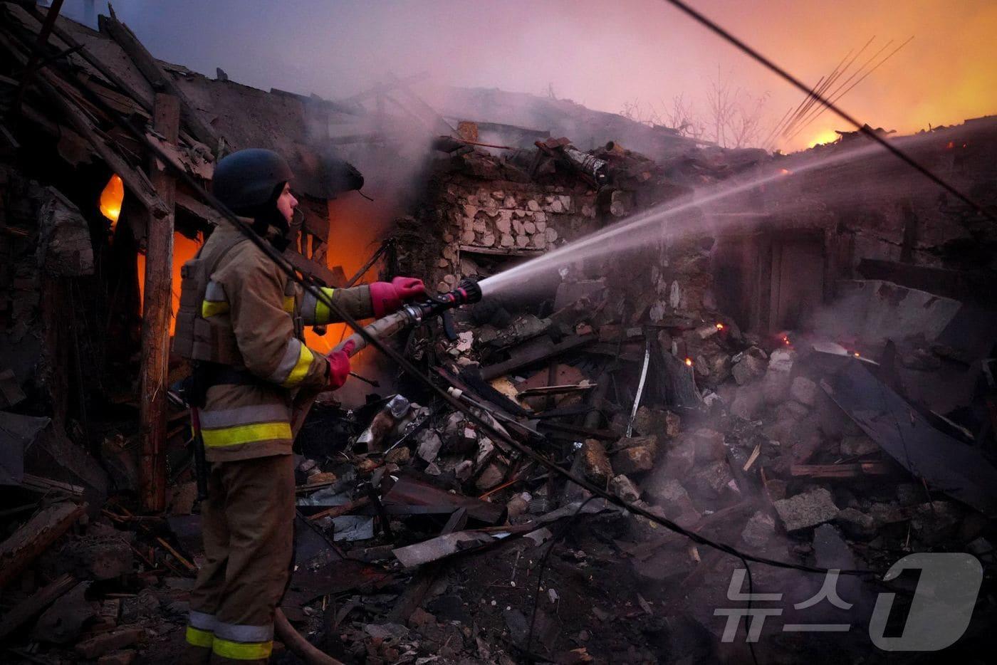 17일(현지시간) 우크라이나 응급 서비스국이 공개한 사진 속에서 우크라이나 구조 대원이 미콜라이우에서 건물 화재를 진압하고 있다. 24.11.17 ⓒ AFP=뉴스1 ⓒ News1 김예슬 기자