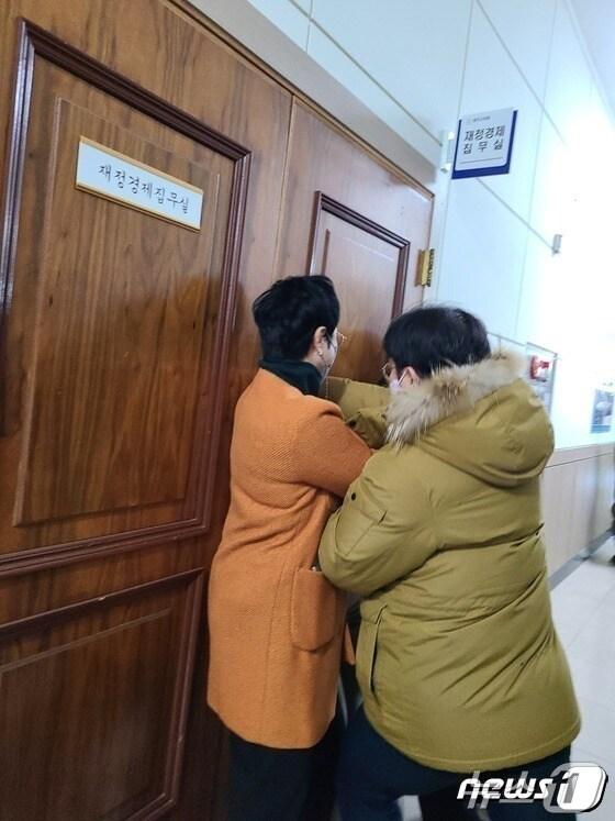 본문 이미지 - 충북 청주시청 본관동 철거에 반대하는 청주시의회 더불어민주당 의원들이 2022년 12월20일 4차 본회의에 참석하려는 같은 당 임정수 의원을 재정경제위원회 집무실에 데리고 간 뒤 설득하고 있다. 임 의원이 집무실을 나오려 하자 민주당 의원들이 문을 막고 있다./뉴스1