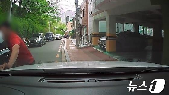 본문 이미지 - 2022년 4월 해운대구 한 도로에서 A씨가 한 차량에 부딪히며 발등을 다쳤다고 주장하는 모습.(부산경찰청 제공)