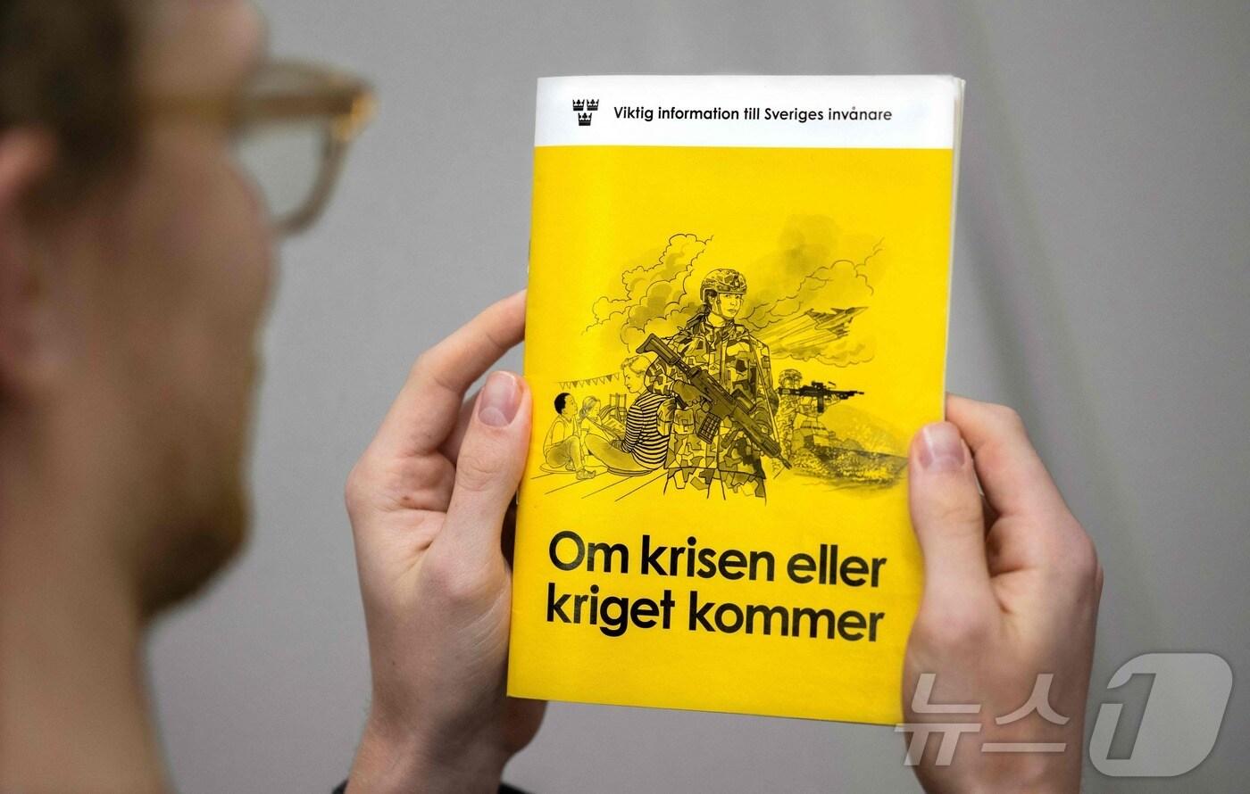2024년 11월 18일 한 스웨덴 남성이 "위기나 전쟁이 온다면"이라는 제목의 비상상황 대비 소책자의 최신 버전을 들고 있다. 스웨덴은 주민들에게 전쟁 가능성에 대비할 것을 촉구하는 약 500만권의 소책자를 이날부터 보내기 시작했고, 이웃 나라인 핀란드는 비슷한 내용의 대비책을 웹사이트를 통해 배포했다. ⓒ AFP=뉴스1