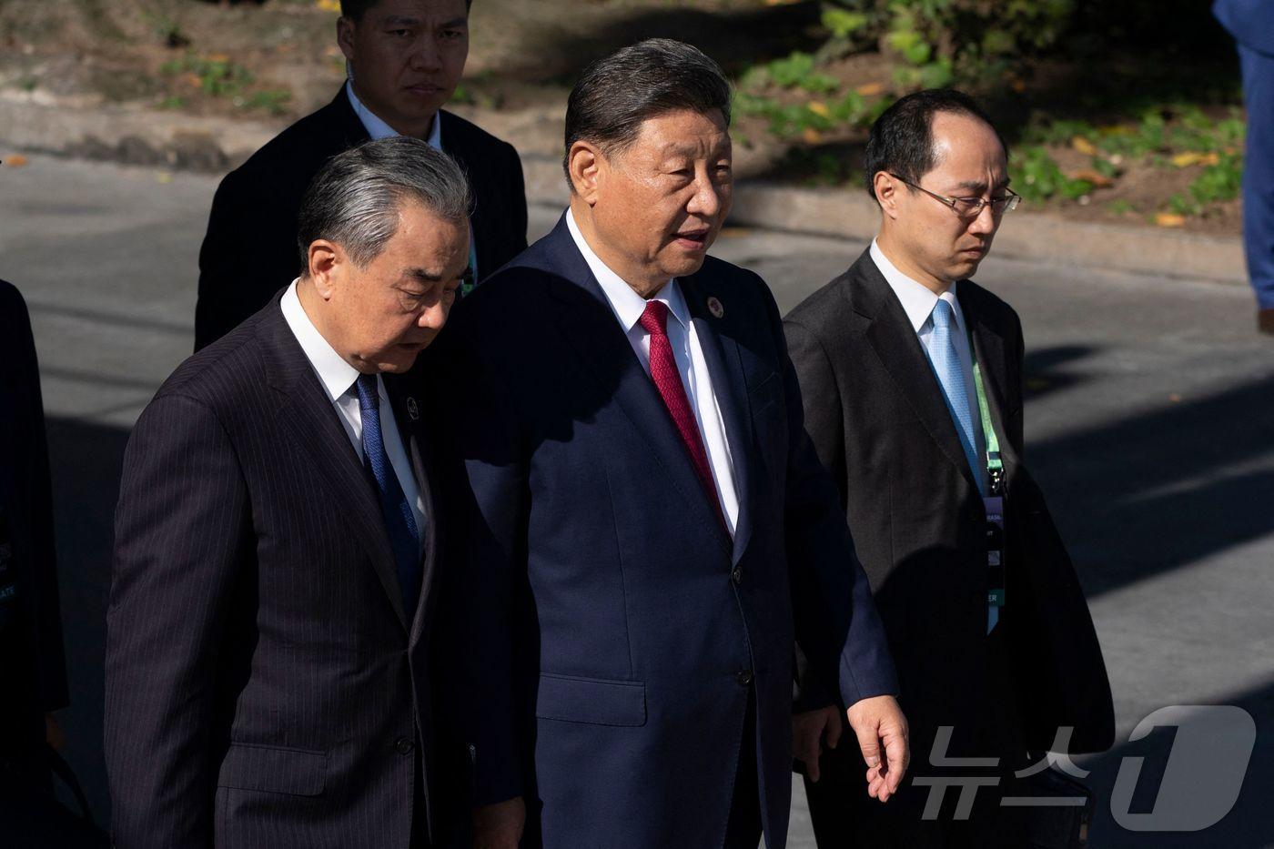 본문 이미지 - 시진핑 중국 국가 주석이 18일 (현지시간) 브라질 리우데자네이루에서 열린 G20 정상회의 중 왕이 외교부장과 단체 사진을 찍으러 가고 있다. 2024.11.19 ⓒ AFP=뉴스1 ⓒ News1 우동명 기자